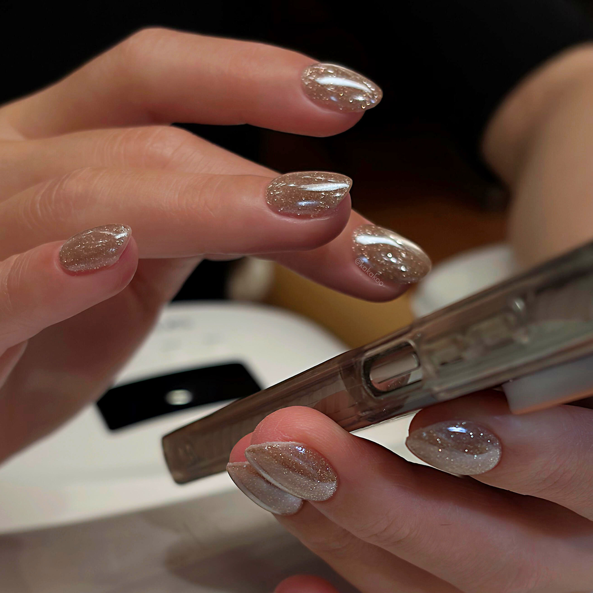Champagne cat-eye manicure shown holding a makeup brush