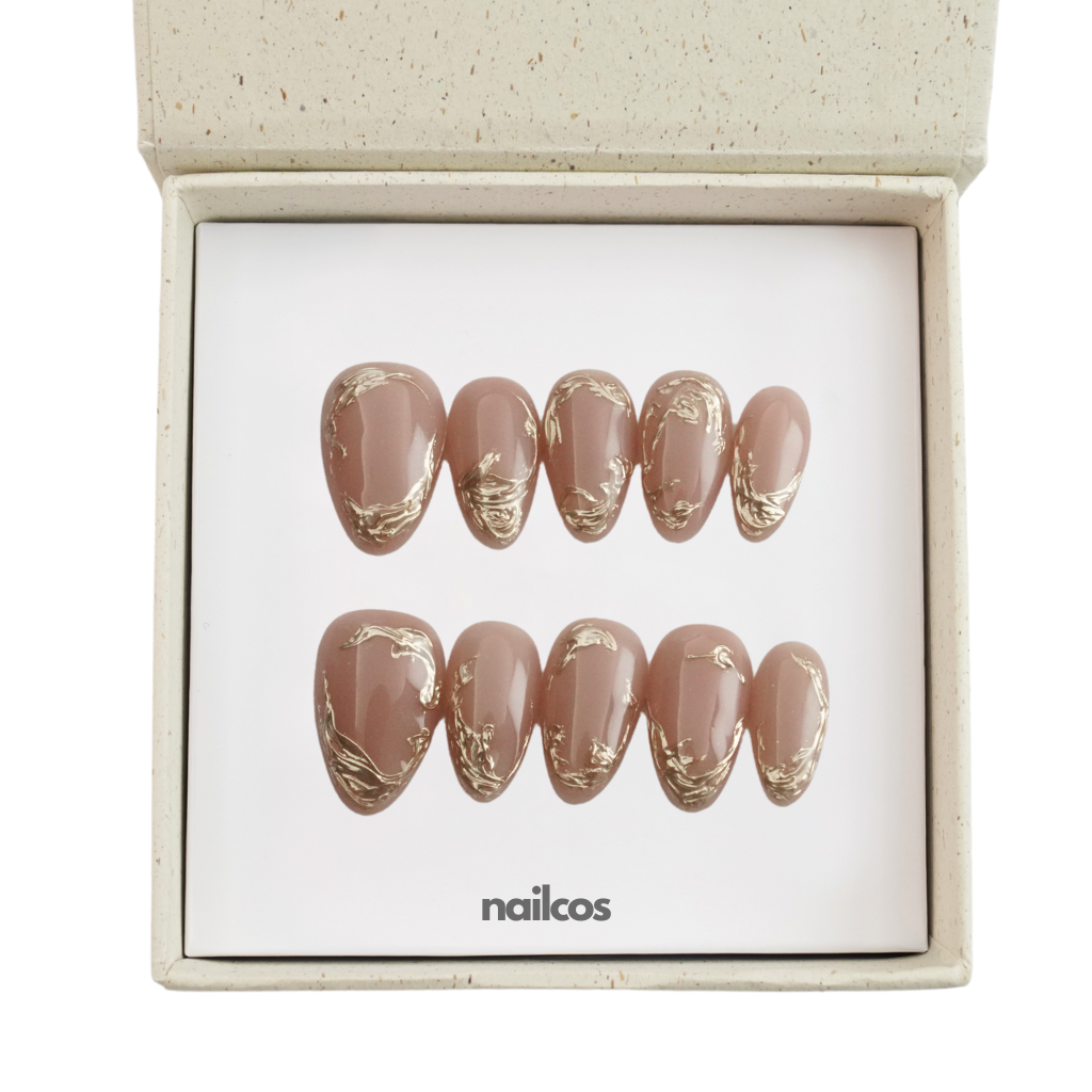 Mocha Swirl set of 10 nude almond press-on nails with metallic swirl details displayed in a box