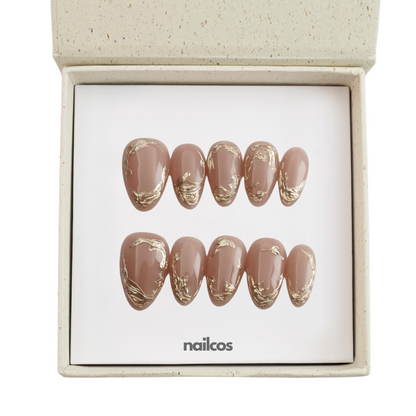 Mocha Swirl set of 10 nude almond press-on nails with metallic swirl details displayed in a box